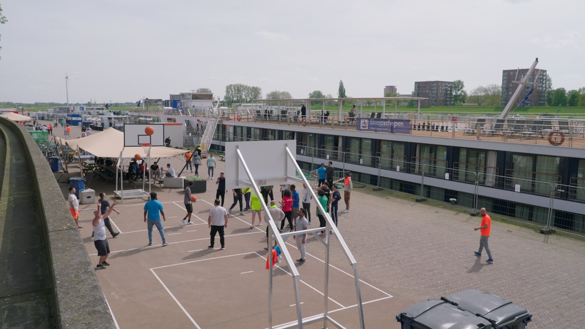 Vluchtelingen spelen basketbal op de sportboulevard aan de Nieuwe Kade